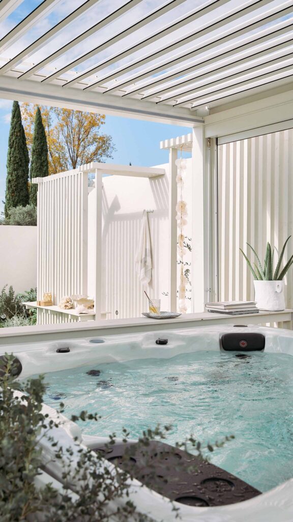 Spa jacuzzi naterial pergola bioclimatique blanche aménagement extérieur sous une pergola