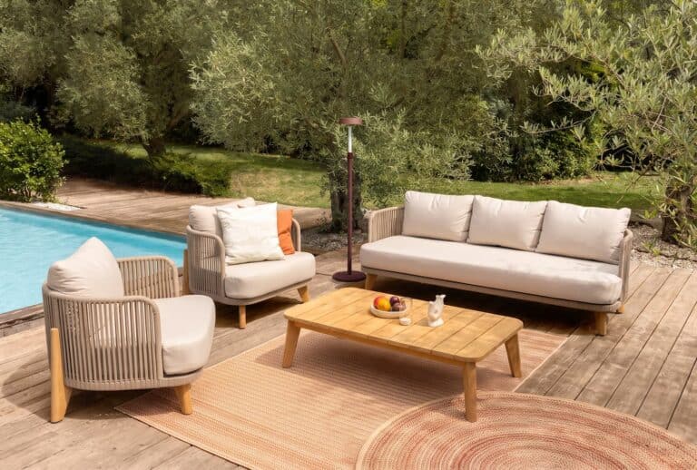 Salon de jardin avec table et chaises dans un espace extérieur lumineux.