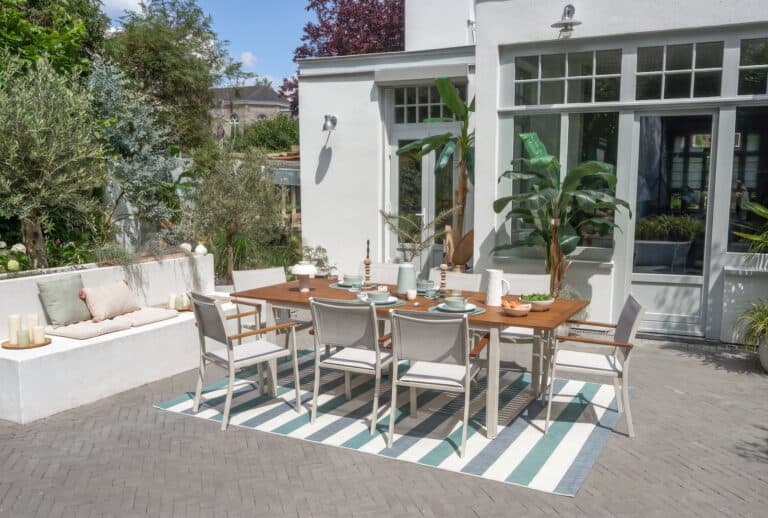Salon de jardin avec table et chaises dans un espace extérieur lumineux.