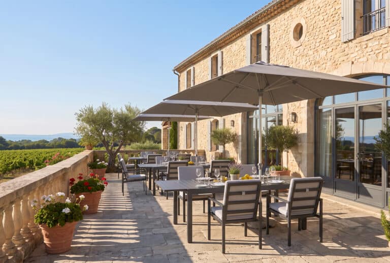 Terrasse extérieure avec parasols et mobilier moderne en pierre.